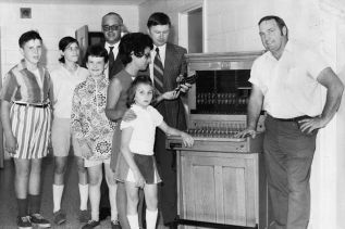 Ellery Thompson (man in centre with striped tie) donated this switchboard to the Sunshine School after it was no longer in use. A member of the school board (man with glasses) was present for this photo.